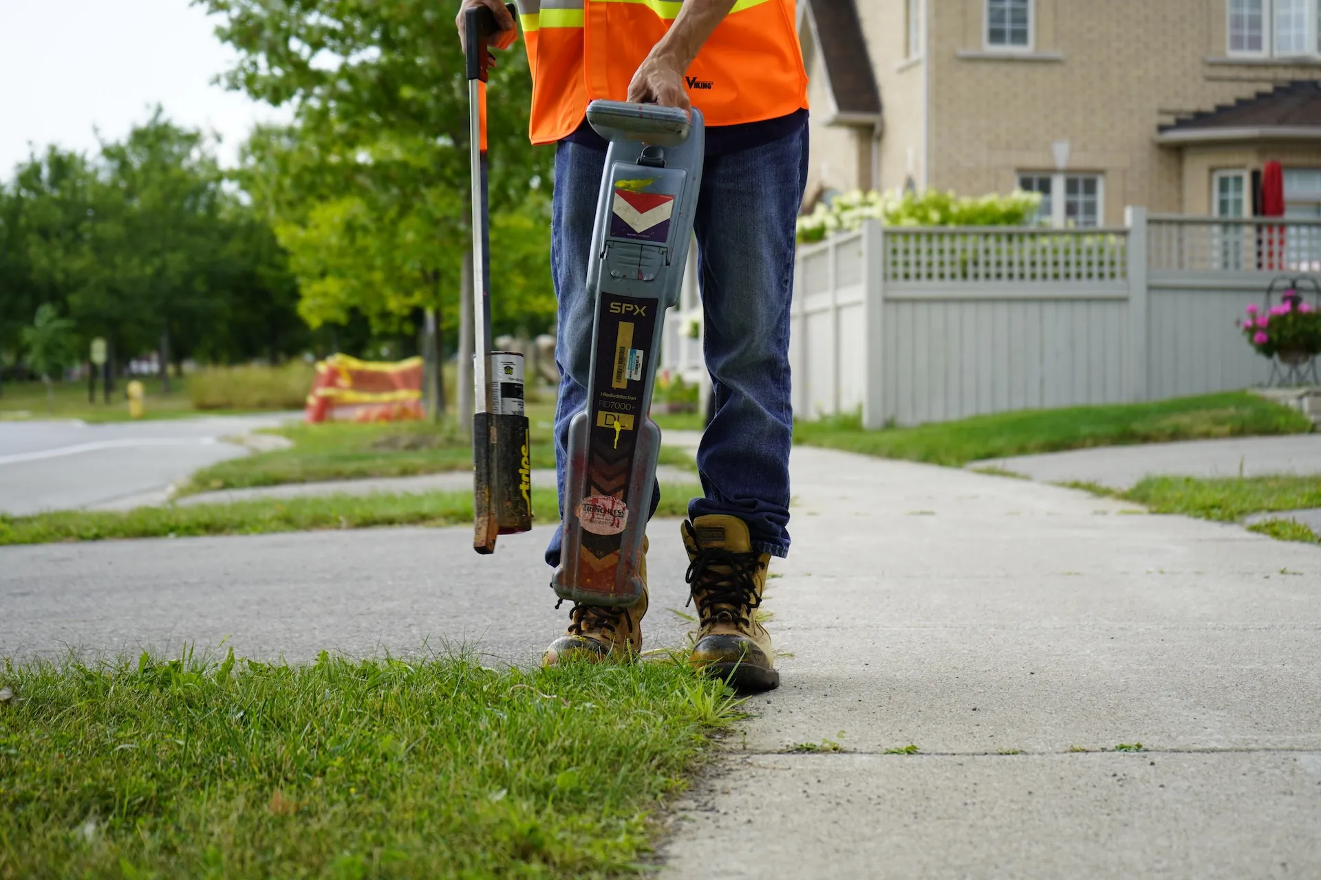 CLI technician using utility locating equipment beside a roadway