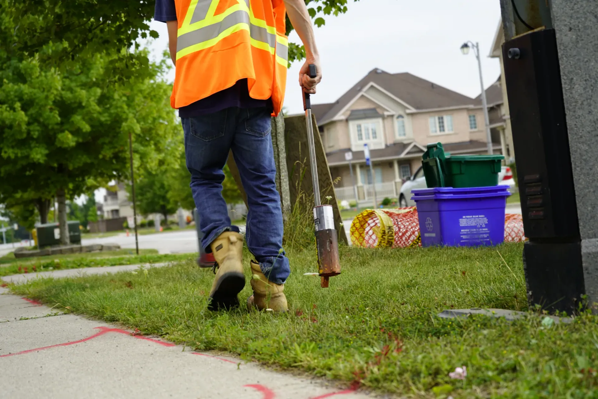 CLI technician sweeping a residential boulevard with a locating wand