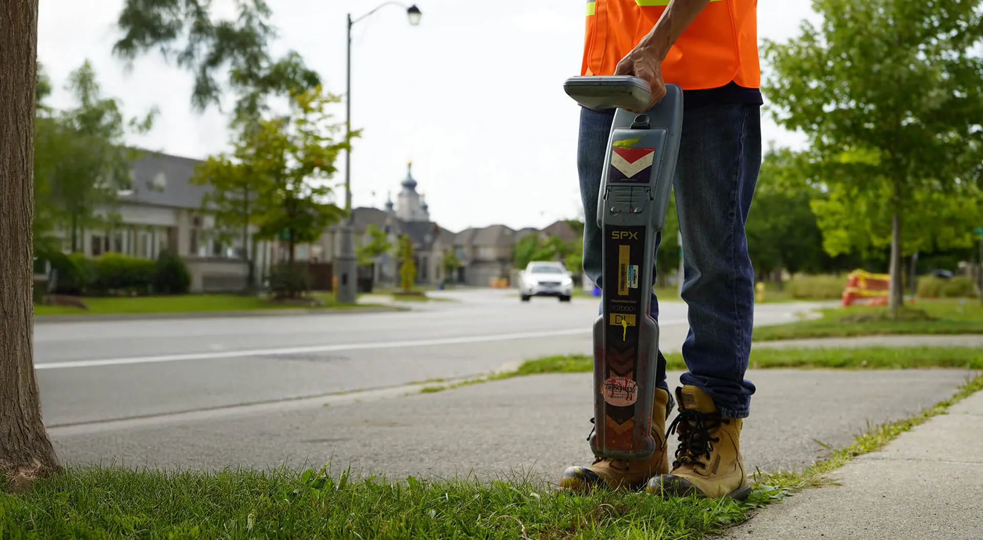 CLI field technician locating underground utilities beside a roadway