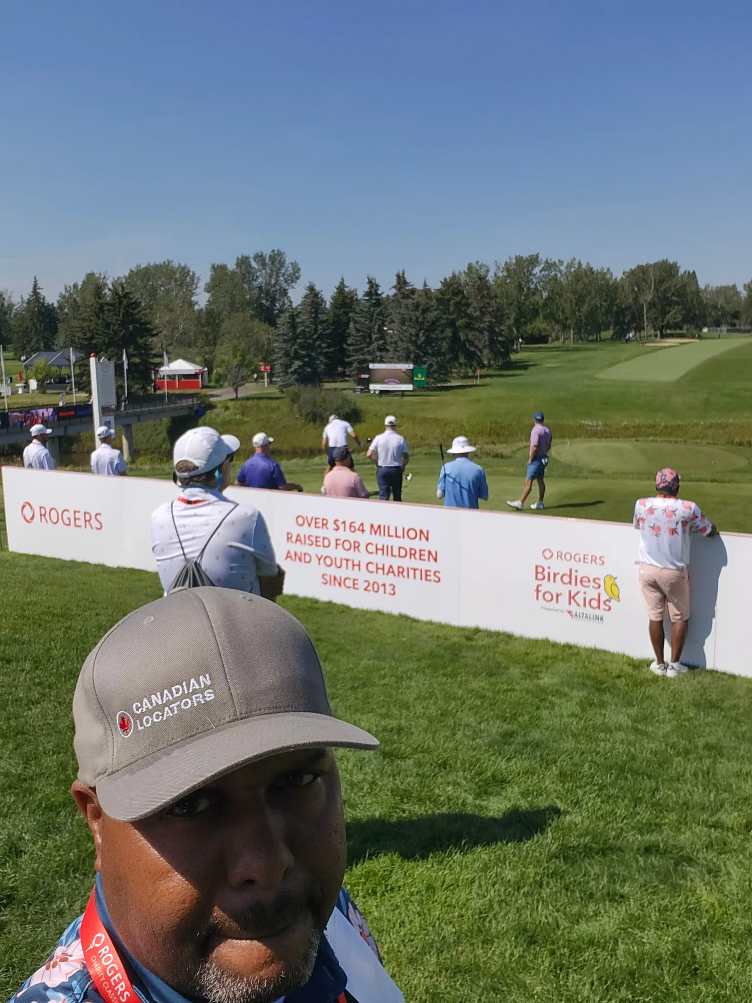 CLI team member at the gallery beside Rogers Birdies for Kids signage noting over $164 million raised since 2013